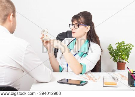 A Dentist Doctor Tells A Patient A Man On The Example Of A Model Of A Dental Jaw And His Disease. Th