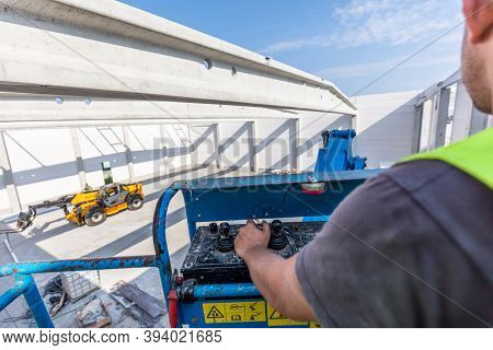 Warehouse construction. Worker operating a mobile elavating work platform