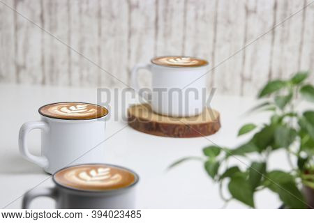 Latte Art Coffee In White Mug With White Background And Green Leaves