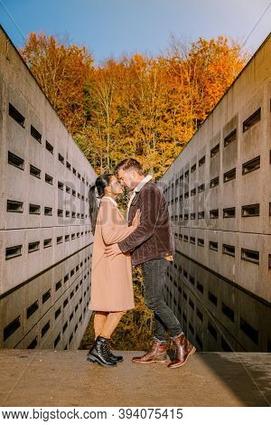 Couple Men And Woman Hiking In The Forest During Autumn And Small Streaming Water River With Fall Co