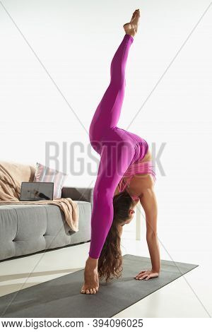 Vitality. Beautiful Young Woman Working Out Indoors, Doing Yoga Exercise On Gray Mat At Home. Long H