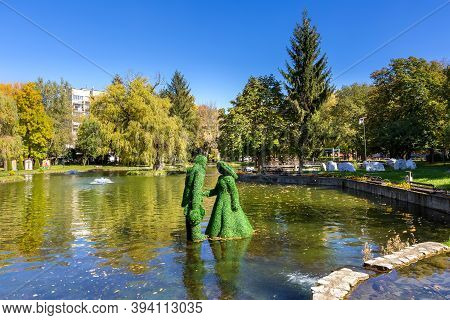 Razlog, Bulgaria - October 20, 2020: Lake, Man And Woman Green Leafs Figurines Panoramic View With A