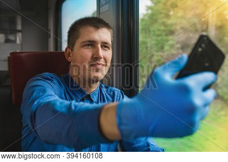 A Young Guy In A Blue Shirt And Protective Medical Gloves With A Phone In His Hands Takes A Selfie O