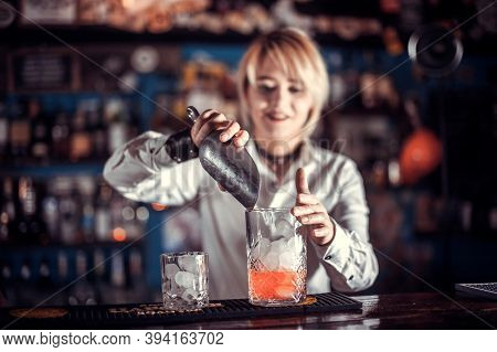 Portrait Of Girl Barman Places The Finishing Touches On A Drink In The Bar
