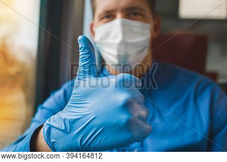Young Guy In A Shirt And A Medical Mask Shows A Cool Thumb Up With His Hand In A Protective Glove