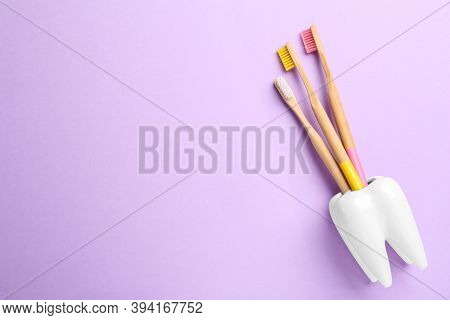 Wooden Toothbrushes In Holder On Violet Background, Top View. Space For Text