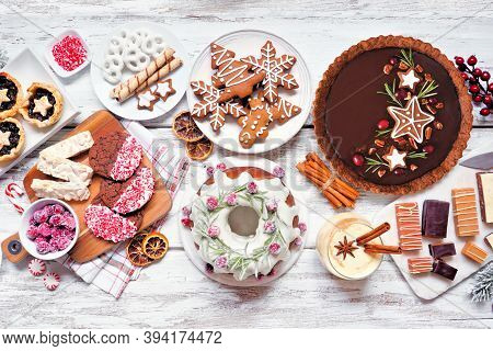 Variety Of Christmas Holiday Desserts And Sweets. Above View Table Scene Over A White Wood Backgroun