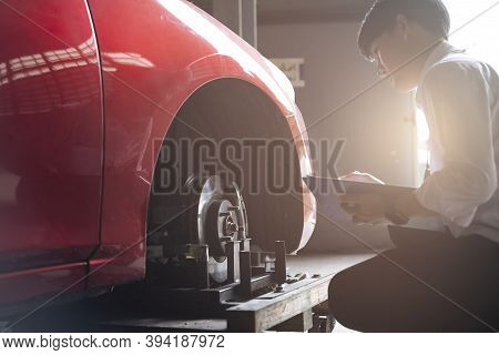 Asian Saleman Inspector Checking Writing On Clipboard Change Wheels In Garage Of Dealership Mechanic