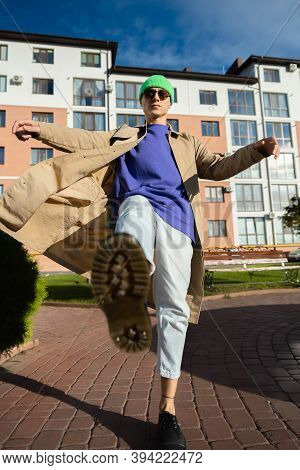 A Young Man In Jeans, Khaki Shoes. In A Jump, Throws His Leg Forward, Kicks, As A Matrix.