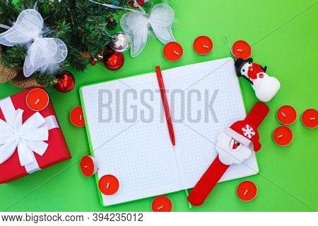 Christmas Gift, Presrnt Box, Many Red Candles, Notepad For Writing And Fir Tree Branches With Toys.