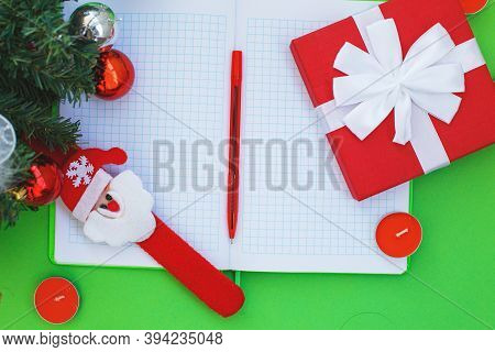 Christmas Gift, Presrnt Box, Many Red Candles, Notepad For Writing And Fir Tree Branches With Toys.