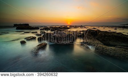 Amazing Seascape For Background. Beach With Rocks And Stones. Low Tide. Motion Water. Clear Sky. Sun