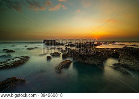 Amazing Seascape For Background. Beach With Rocks And Stones. Low Tide. Motion Water. Clear Sky. Sun