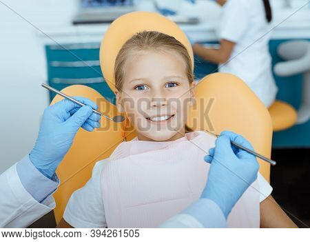 Modern Visit To Dentist And Painless Dental Treatment. Portrait Of Little Girl In Medical Chair And 