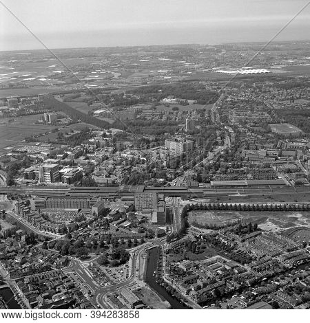 Leiden, Holland, June 03 - 1983: Historical black and white aerial photo of the Station quarter in Leiden and railway station