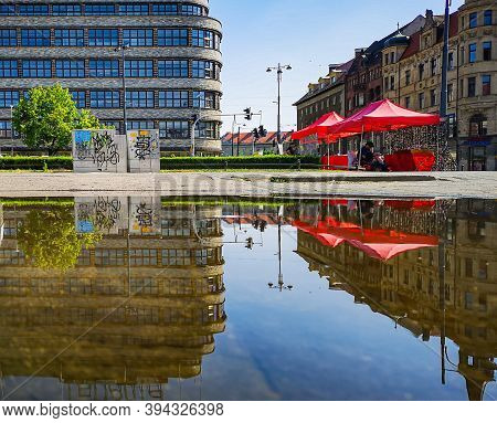 Wroclaw June 14 2019 Renoma Shopping Mall And Red Tents With Sunglasses Reflected In Large Puddle