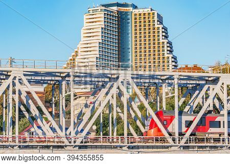 Sochi, Russia - October 08, 2020: Passenger Train Moves Through The Bridge On The Prestige Hotel Bac