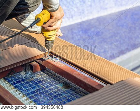 Man Assembling Composite Deck Using Cordless Screwdriver.