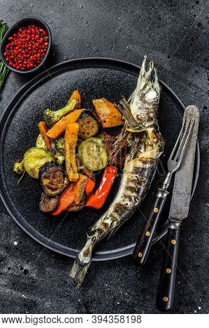 Baked Whole Icefish With Grilled Vegetables. Black Background. Top View