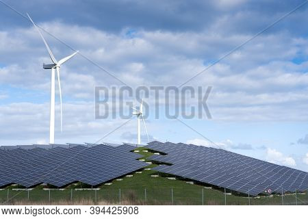 Wind Turbines And Solar Panels Form Alternative Enery Plant In The Netherlands Under Blue Sky With C