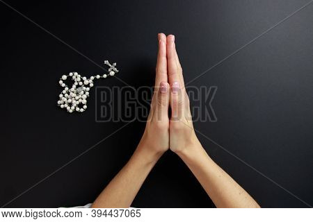 Spiritual Prayer To God, With Verve Or Rosary In The Hands Of A Young Girl. Black Background. Close-