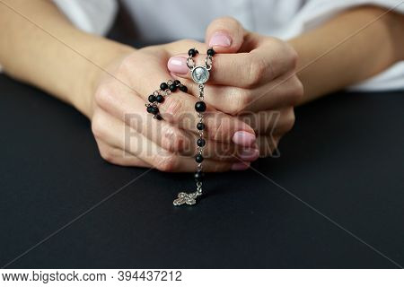 Spiritual Prayer To God, With Verve Or Rosary In The Hands Of A Young Girl. Black Background. Close-