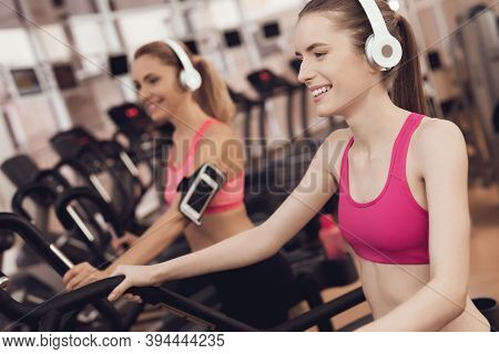 Mother And Daughter Running On Treadmill At The Gym. They Look Happy, Fashionable And Fit.