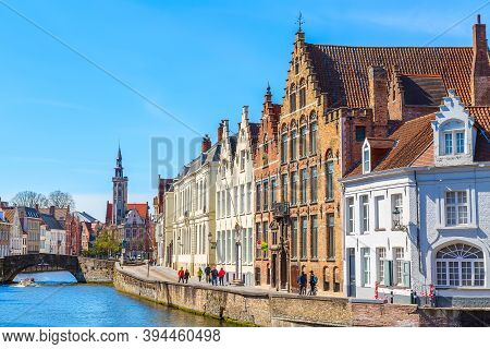 Bruges, Belgium - April 10, 2016: Panorama With Canal, Cathedral Tower And Colorful Traditional Hous