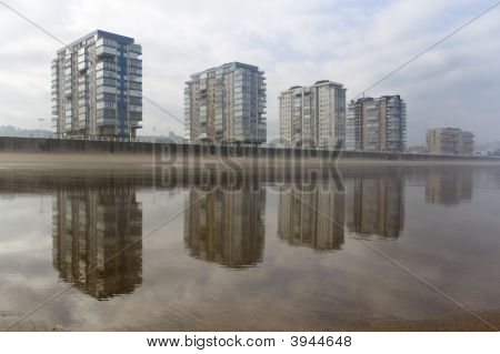 Прибрежный город, отражение на пляже