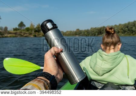 A Man Holds A Thermos In His Hand. A Man With A Girl In The Boat.