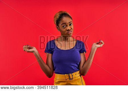 Displeased Lady In Earrings In A Blue T-shirt Stands And Posing At The Camera.