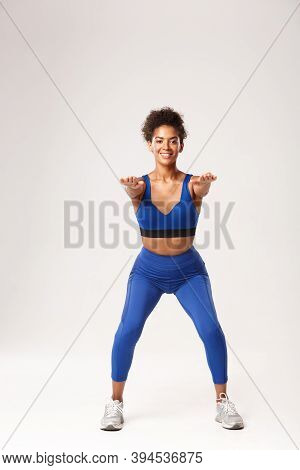 Full Length Of Attractive African-american Fit Woman In Sport Clothing, Stretch Hands Foward And Mak