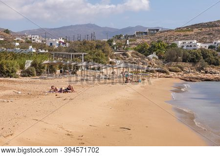 Paralia Koumpara Beach, Ios, Greece- 20 September 2020: People Sunbathing On Sand And The Lawn Chair