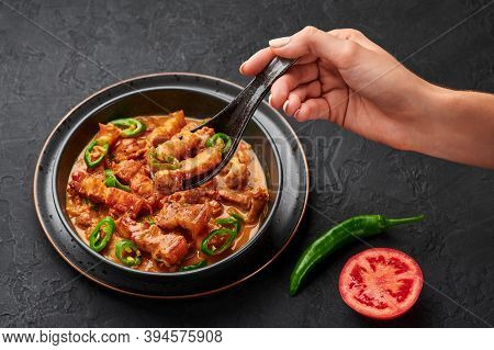 Bicol Express Stew In Black Bowl On Dark Slate Table Top. Filipino Cuisine Spicy Pork Belly Coconut