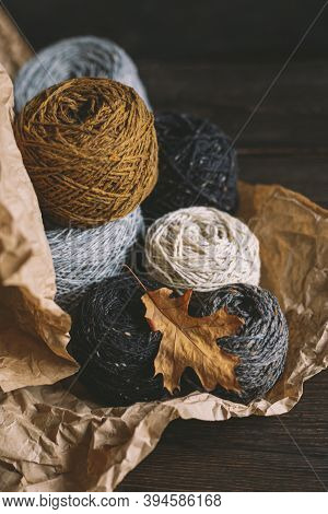 Cozy Balls Of Yarn For Hand Knitting With Dry Oak Leaf On A Dark Background. Autumn Background For H