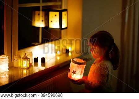 Little Kid Girl Sitting By Window With Selfmade Hand Crafted Lanterns With Candles For St. Martin Pr