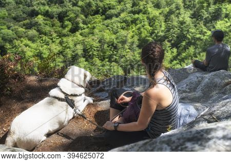 Great Barrington, Massachusetts.  September 15, 2019. A Couple And Dog Sitting On A Rocky Ledge On M