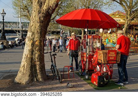 London, Great Britain, April 21, 2018 : Crowd On South Bank At Sunset, With A Little Popcorn Shop.