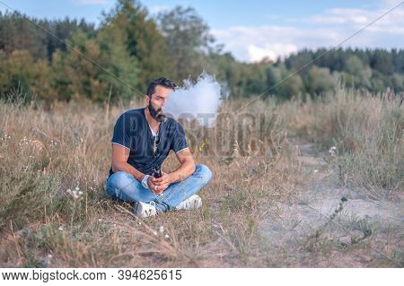 Brutal Vape Man Smoking An Electronic Cigarette In The Outdoors. Getting Rid Of Nicotine Addiction.
