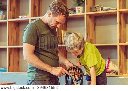 Father Blond Son Boy Play Lotto, Round Sphere Spins With Small Orange Balls Numbers Written, Table L