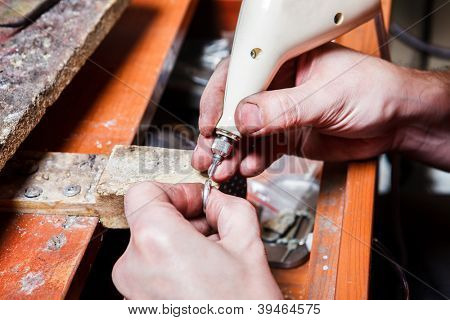Manos del joyero grabado en el anillo