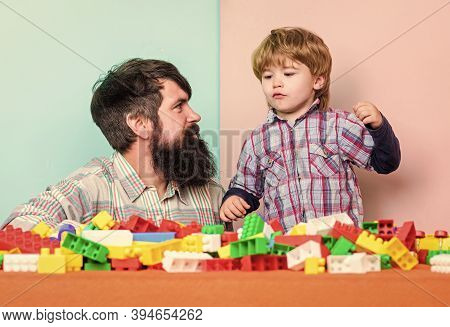Dad And Kid Build Plastic Blocks. Child Care Development. Family Leisure. Father And Son Create Cons