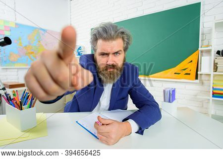 Back To School. Serious Teacher Points At Camera. Learning, Education, School Concept. Teachers Day.