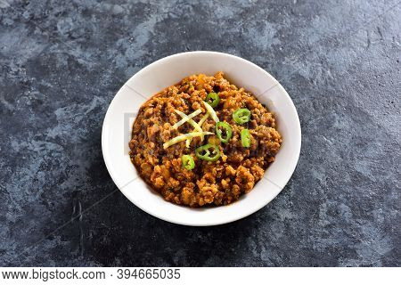 Close Up View Of Keema Curry In Bowl Over Blue Stone Background With Free Text Space. Indian And Pak