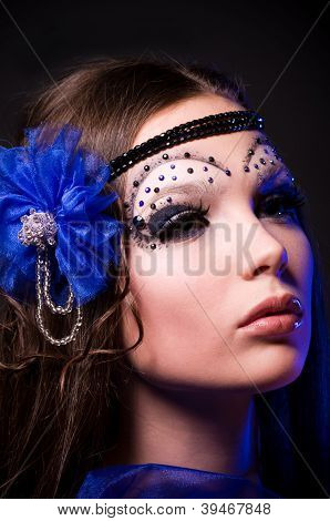 Красивая молодая женщина в модной одежды с косметикой