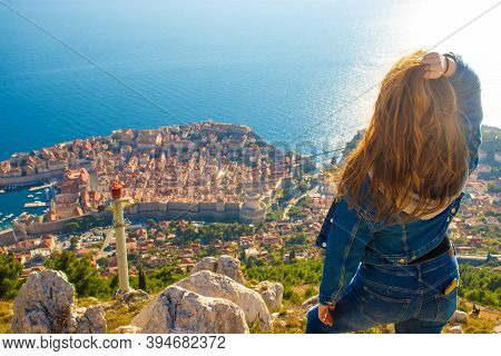 Over The Shoulder View Of A Girl Standing On Top Of The Srd Mountain, Looking Down On Dubrovnik City