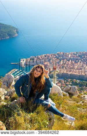 Vertical Shot Of A Brunette Sitting On The Stones On The Srd Mountain Above The City Of Dubrovnik, P