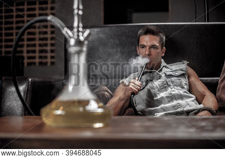 Man Smoking Hookah In The Shisha Hose.