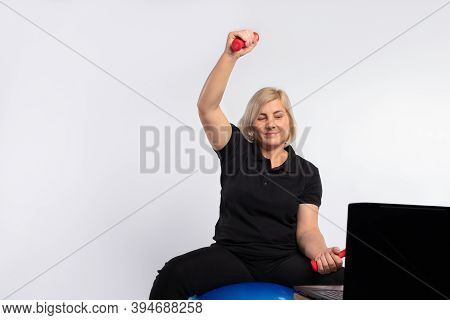 Trainings Online. Senior Woman Doing Exercises With Dumbbells. Fitness Concept During A Pandemic Pho