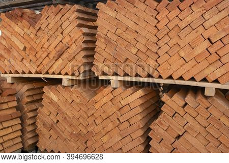Diagonal Stacking In Two Columns Towards The Center. Wooden Pallets With Red Building Bricks Stacked